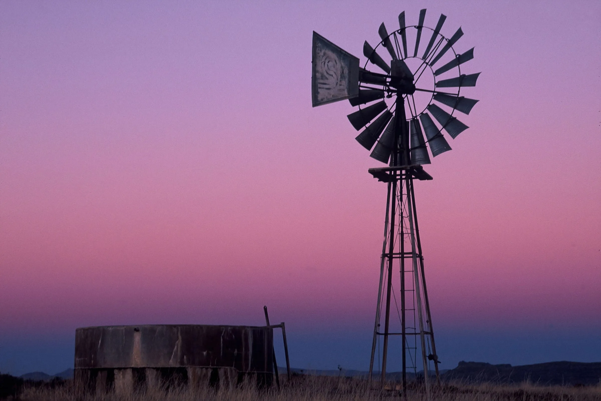 A wind pump standing in evening light on open Central Karoo veld
